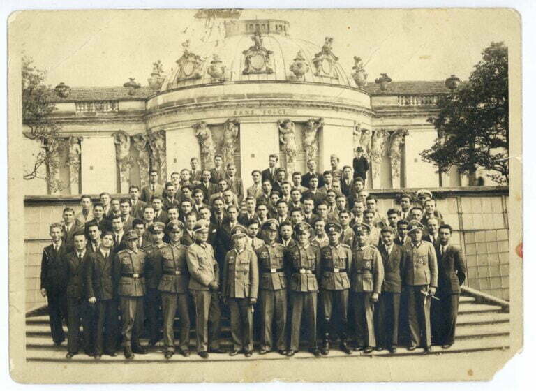 Absolvențiilor liceelor militare selecționați pentru a urma școli militare de ofițeri activi împreună cu instructorii și ofițerii germani, în timpul vizitei la Postdam, pe scările principale ale Palatului Sanssouci pe 21 iunie 1942 (colecția colonel Gheorghe Cojocea).